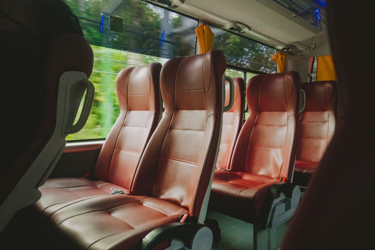 Interior view of a luxury bus with red leather seats.