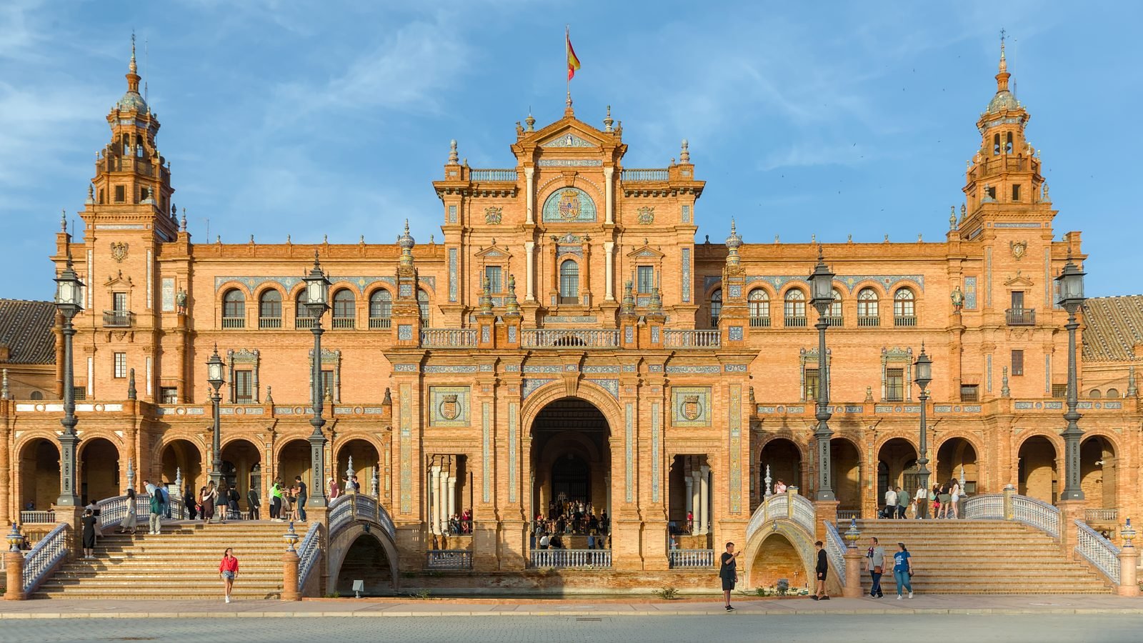 Plaza de España in Seville showing the main building and bridge over the canal in late afternoon light.