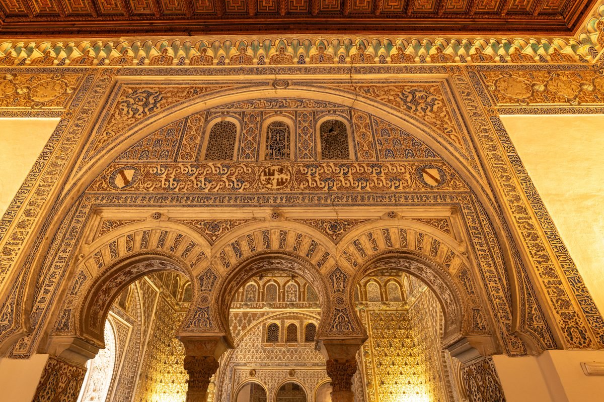 Intricate Moorish archway with detailed tilework inside the Alcázar of Seville.