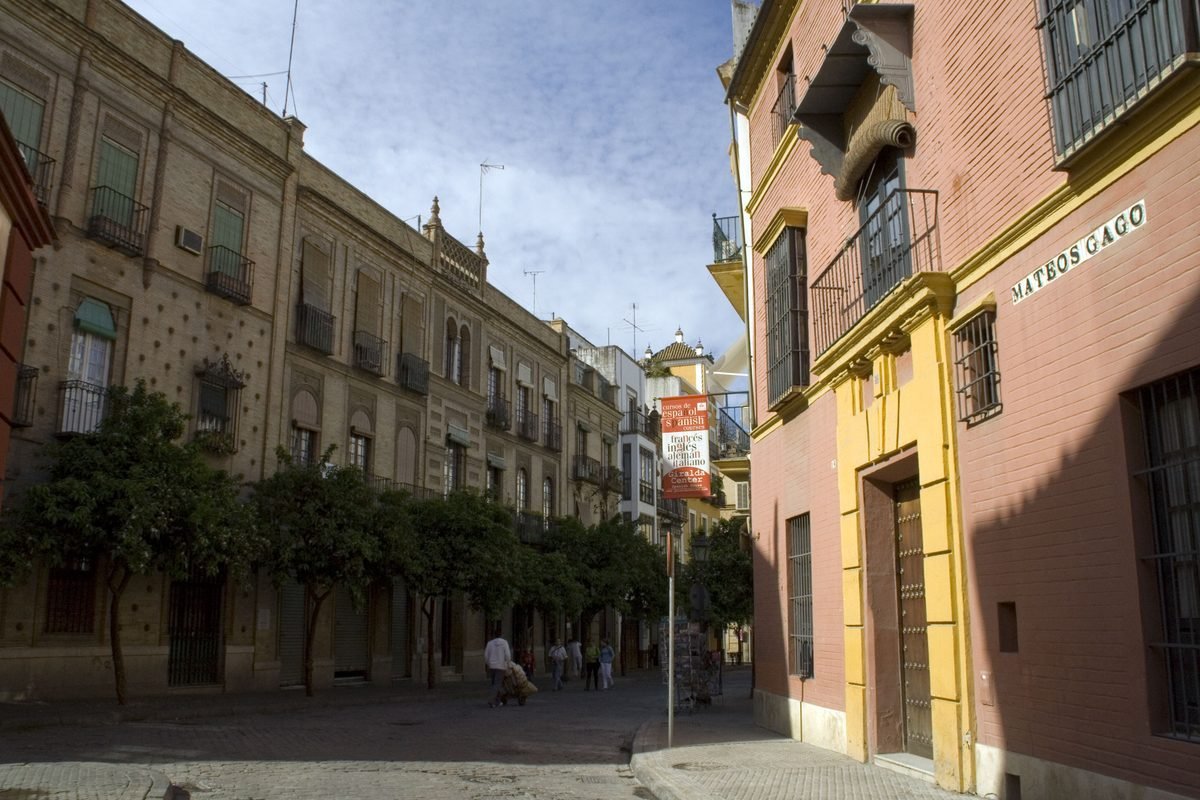 Calle Mateos Gago street scene with historic buildings and trees in Seville.