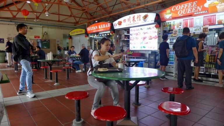 Diners at the red stools of Maxwell Food Centre hawker centre in Singapore