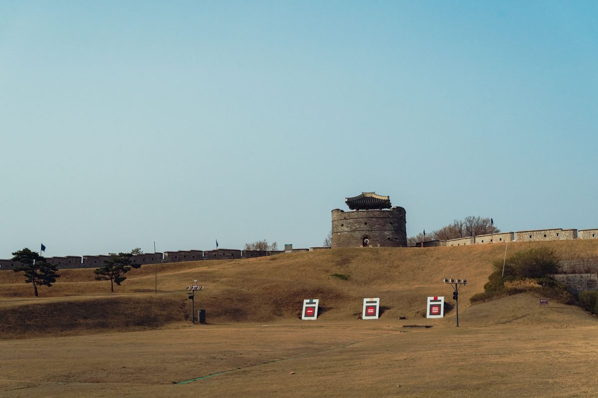 Stone guard tower along the curved fortress wall under a blue sky