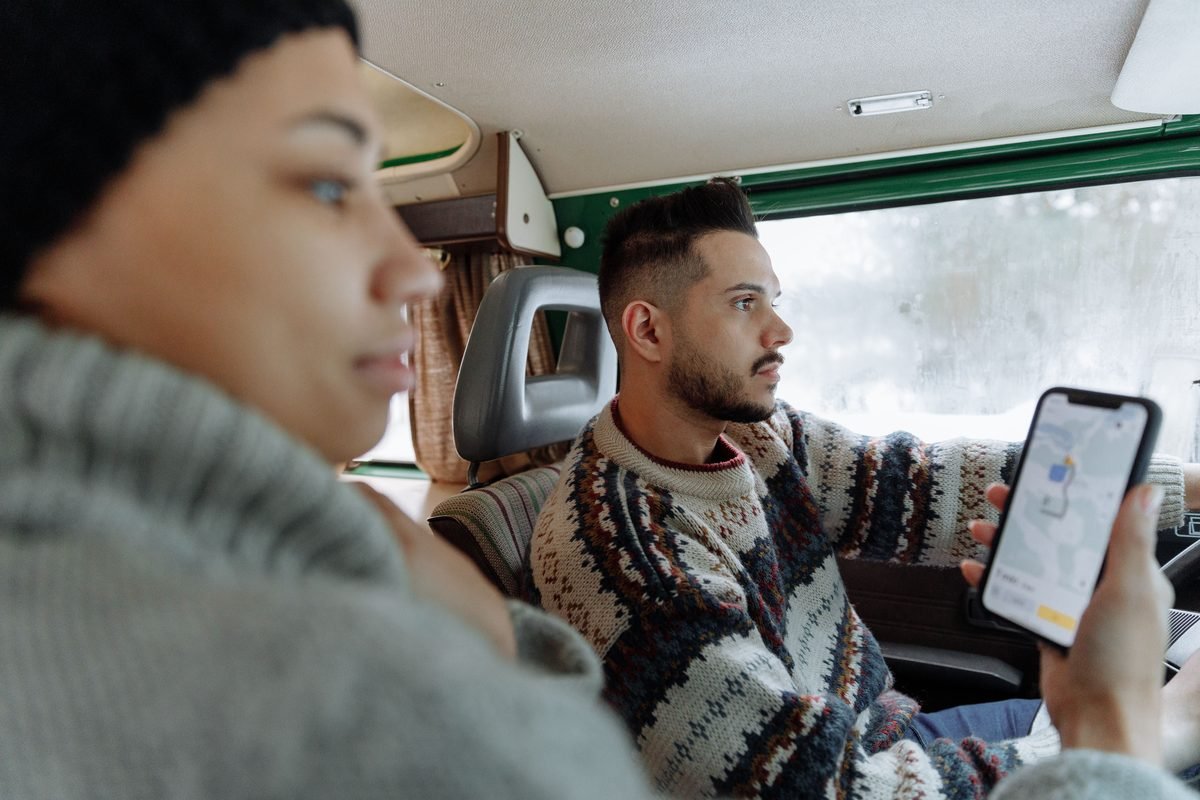 Couple checking a navigation app on a smartphone in a campervan