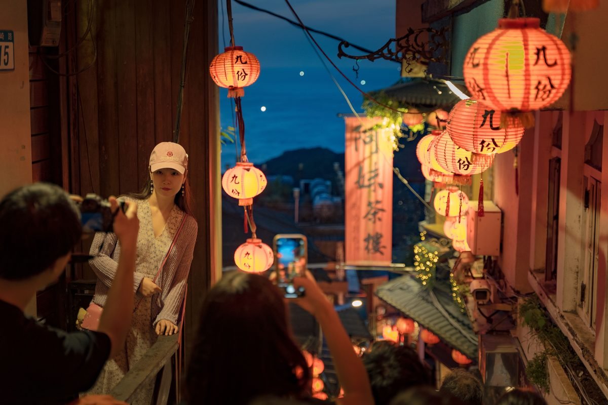 Couple enjoying the illuminated streets of Jiufen at dusk with traditional lanterns