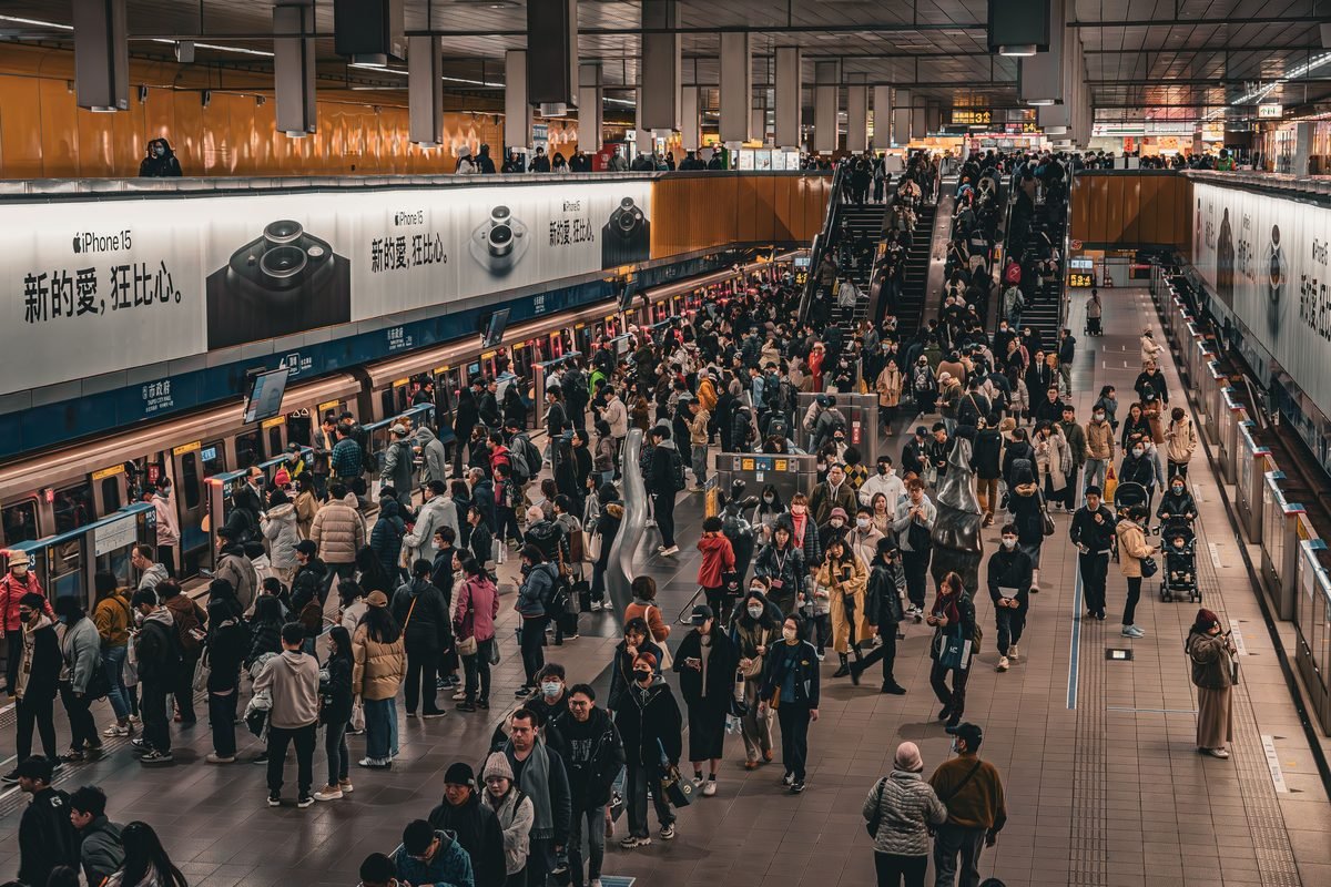 Busy crowd at a modern metro station platform in Taipei.