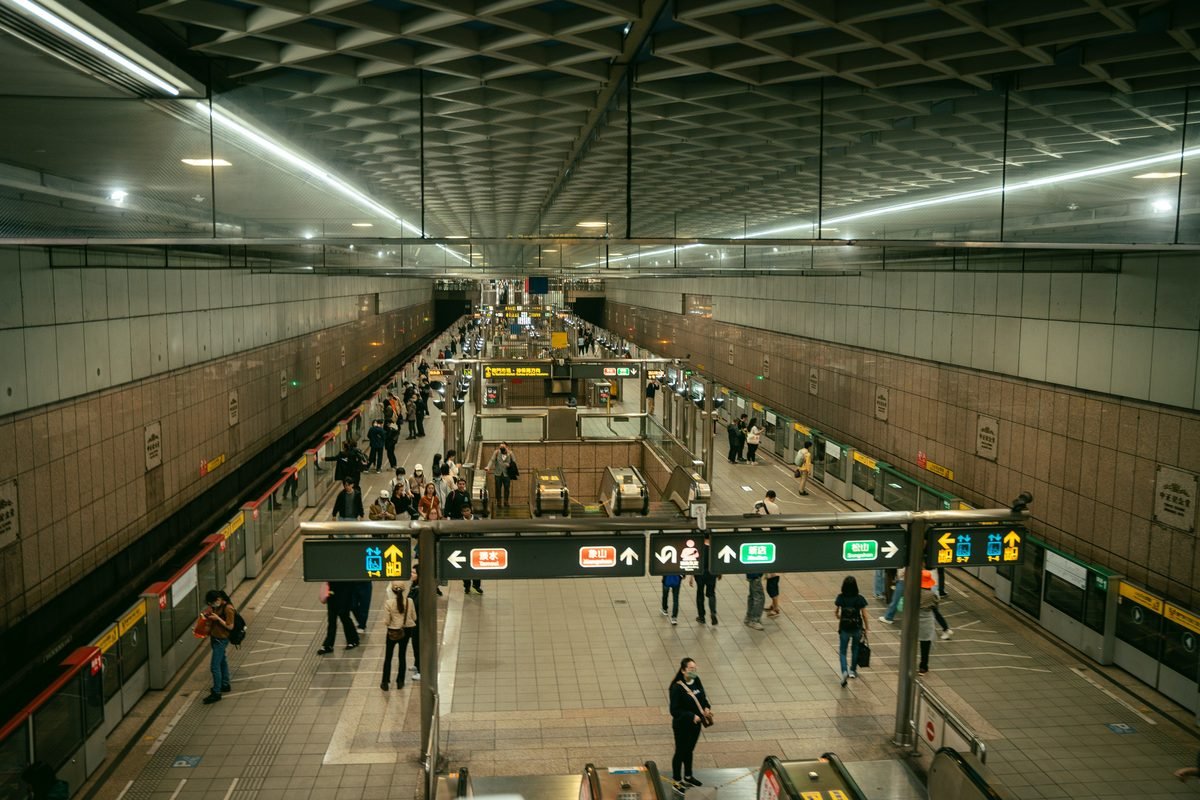 Elevated view of a clean metro station interior with commuters.