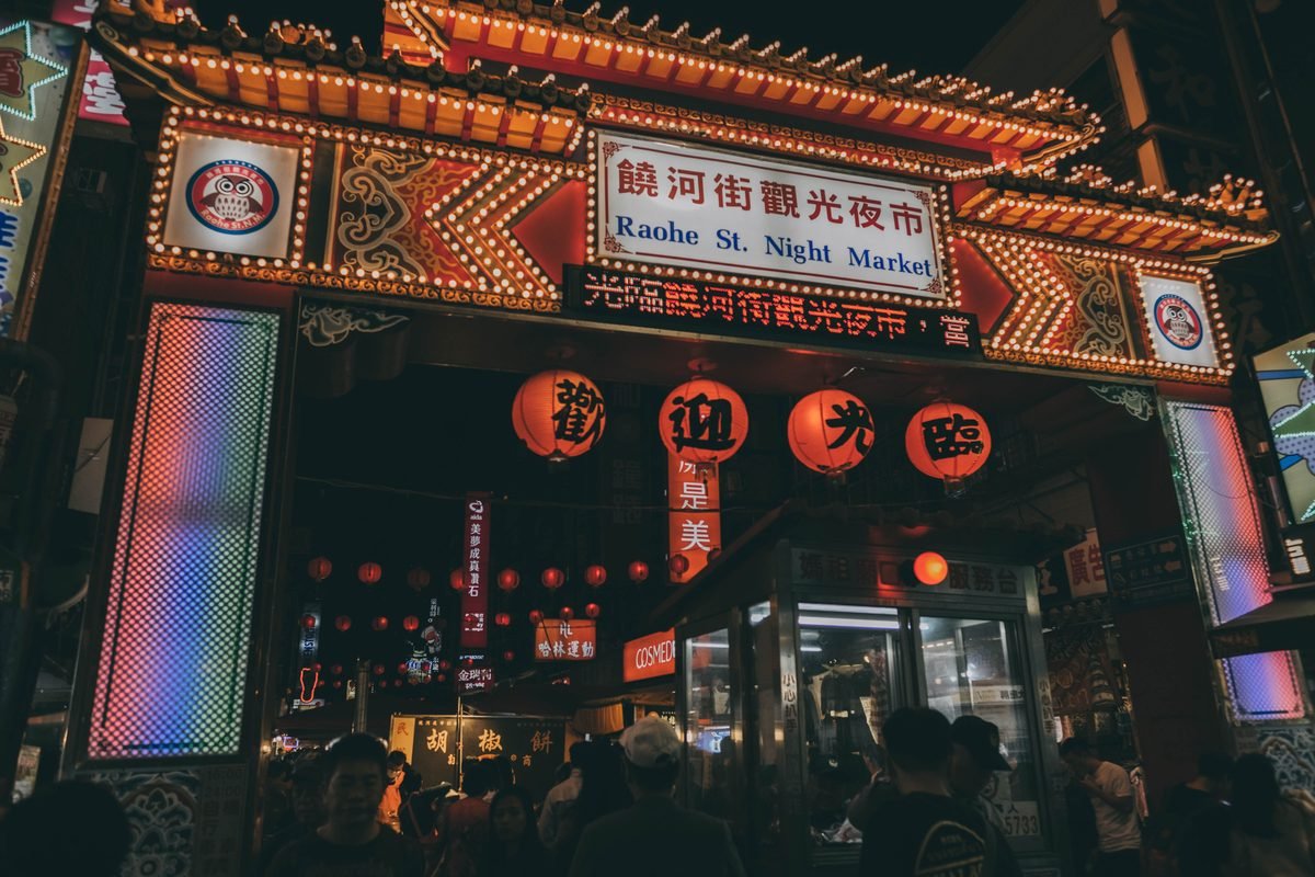 Illuminated Raohe Street Night Market entrance featuring traditional lanterns in Taipei