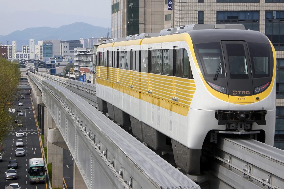 Daegu Metro Line 3 monorail train running on its elevated track above the city