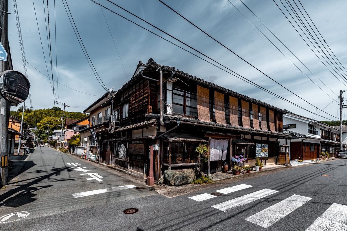 Traditional Japanese wooden buildings at a quiet street intersection.