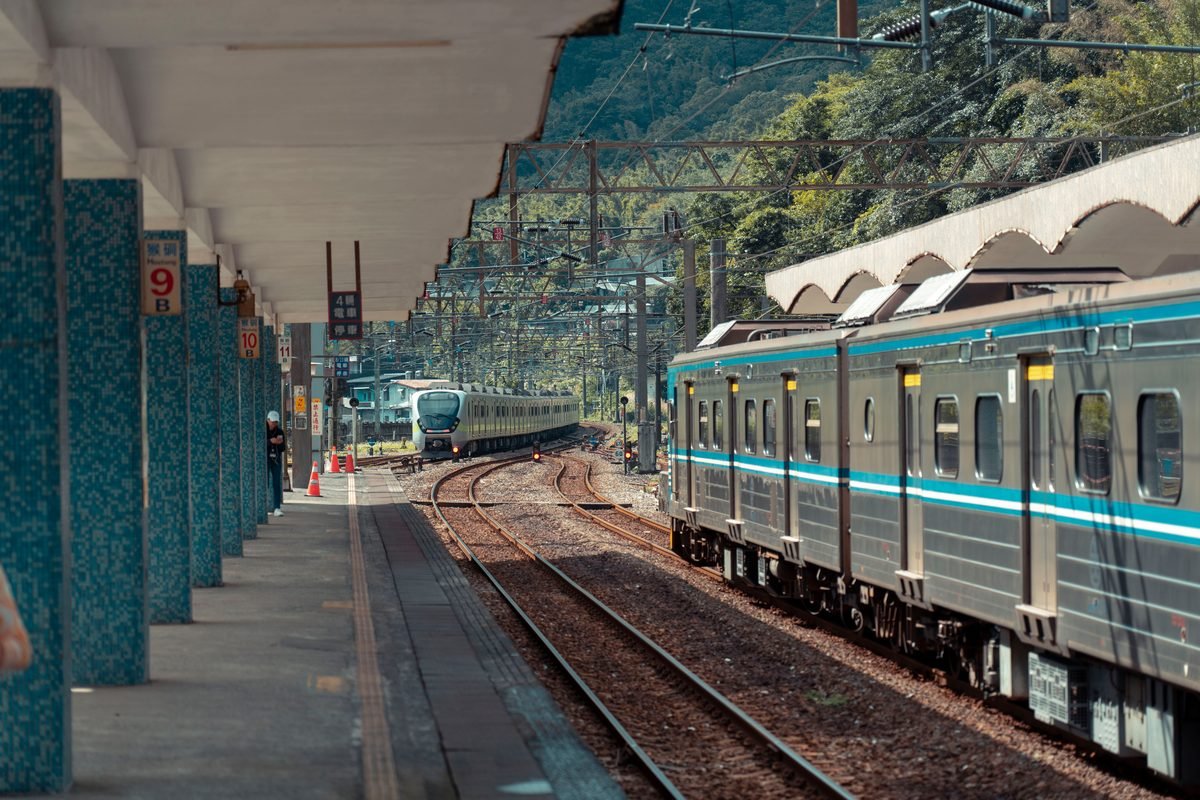 Passenger train parked at a covered rural Japanese railway platform.