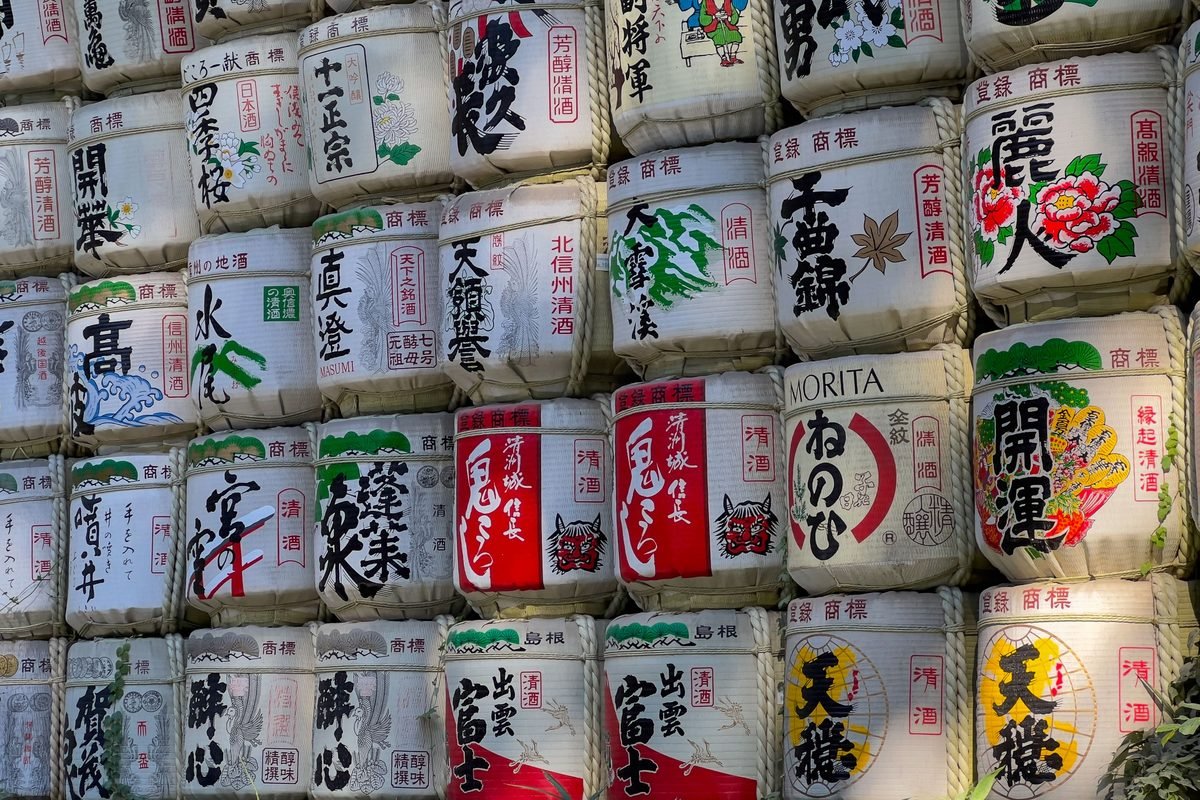 Stacked traditional decorative sake barrels at a Japanese cultural site.