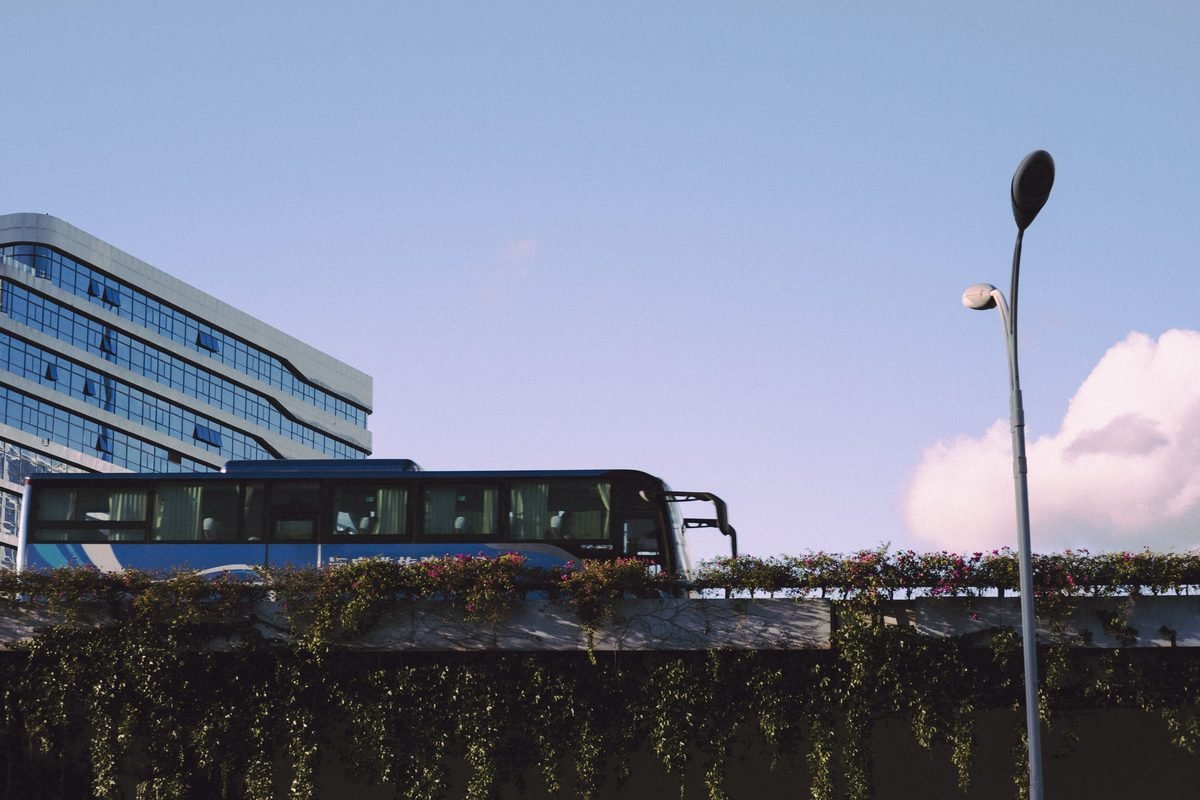 Sleek bus passing by a modern glass building