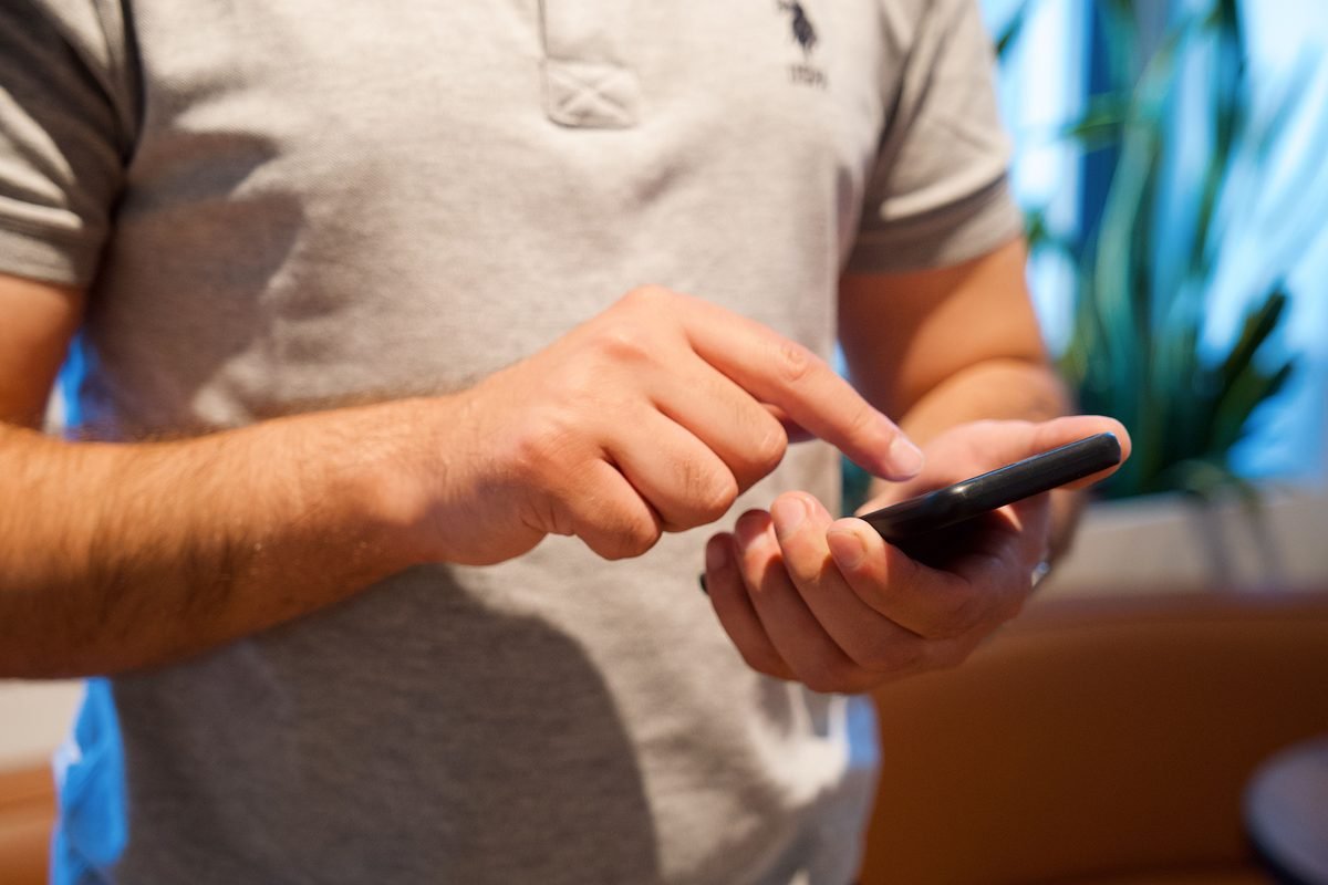 Close-up of a person using a smartphone to set up digital transit cards.