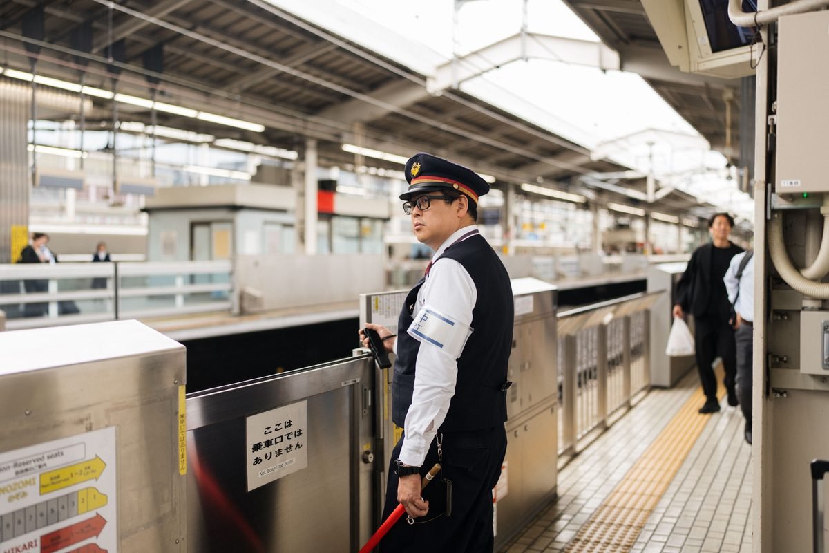 Security guard standing on a platform at Tokyo train station.