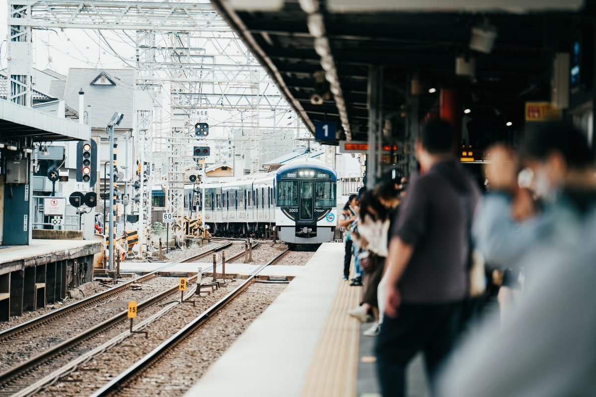 Train arriving at a Japanese station with waiting passengers