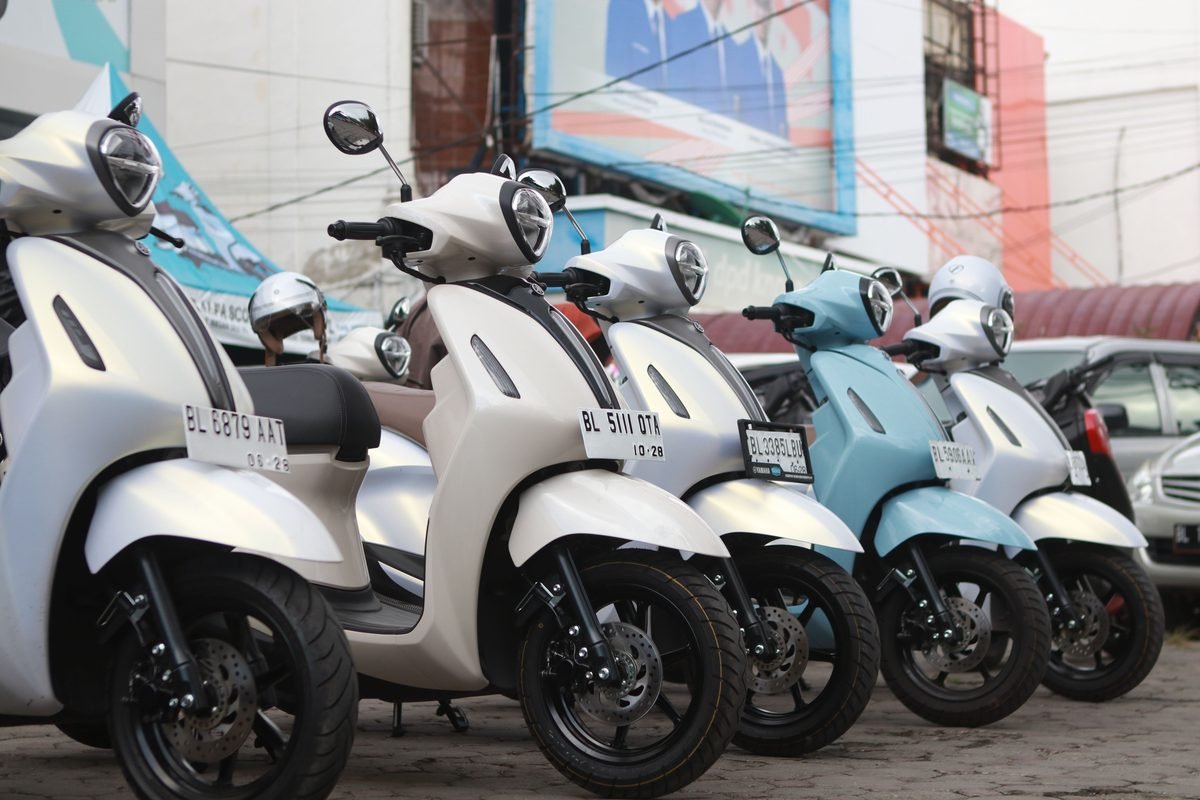 Lineup of Yamaha scooters parked outside on a city street