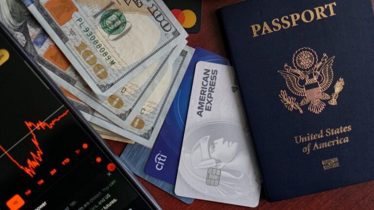 US passport, credit cards, cash, and phone on a table