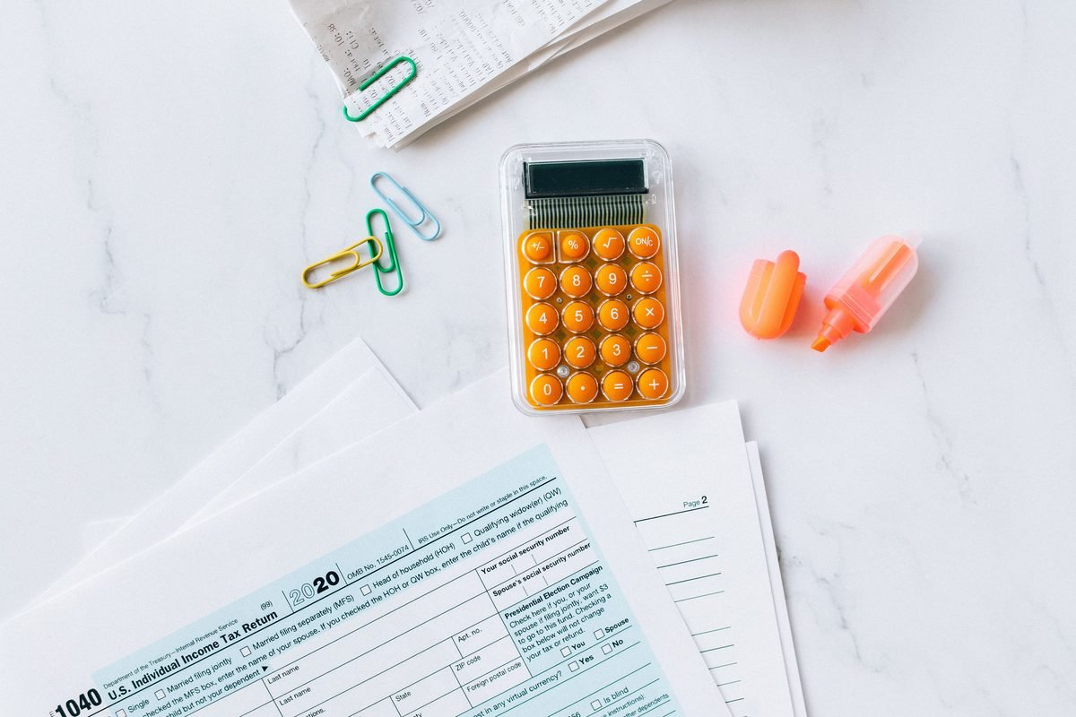 Tax forms, calculator, and office supplies on a desk