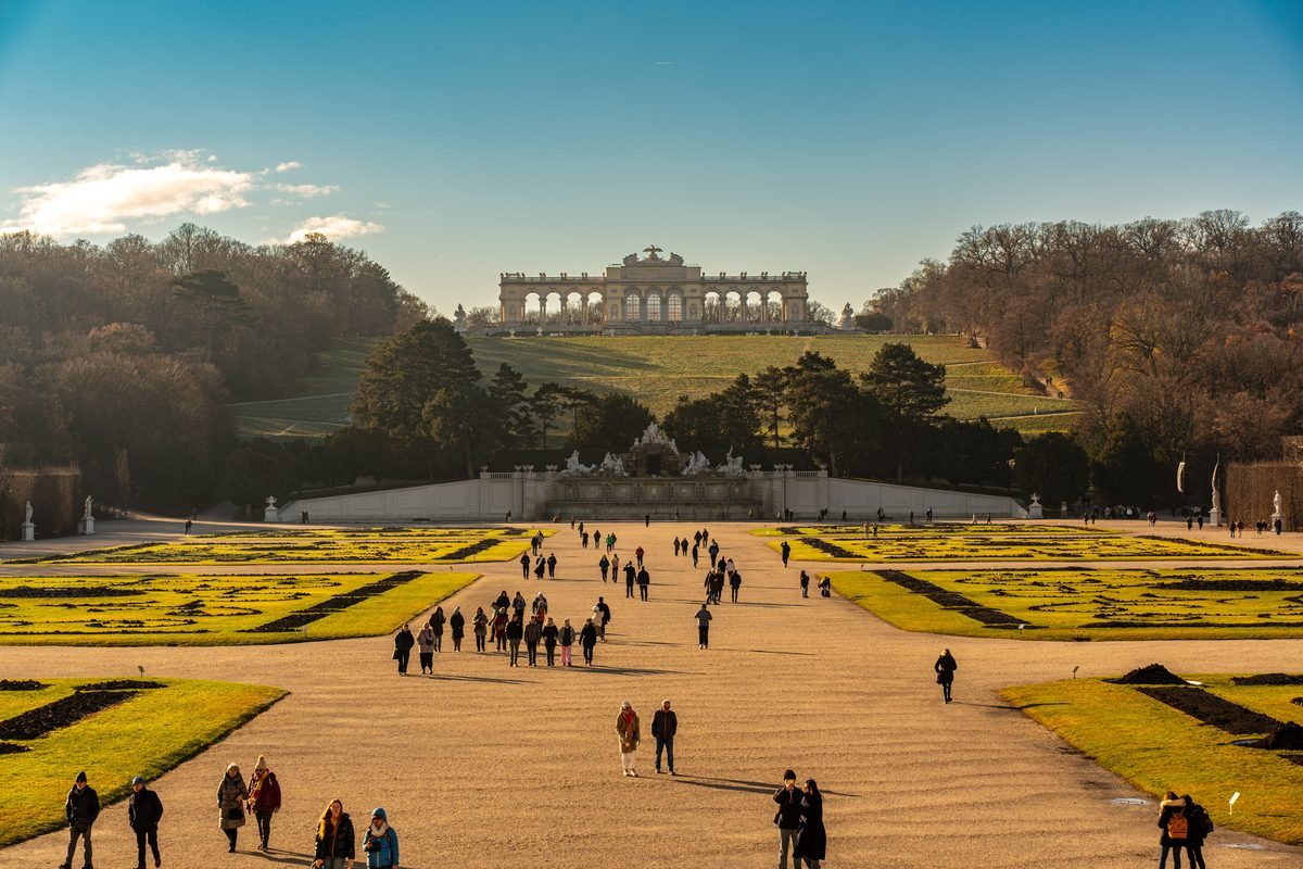 Visitors walking through the expansive gardens toward the Gloriette.