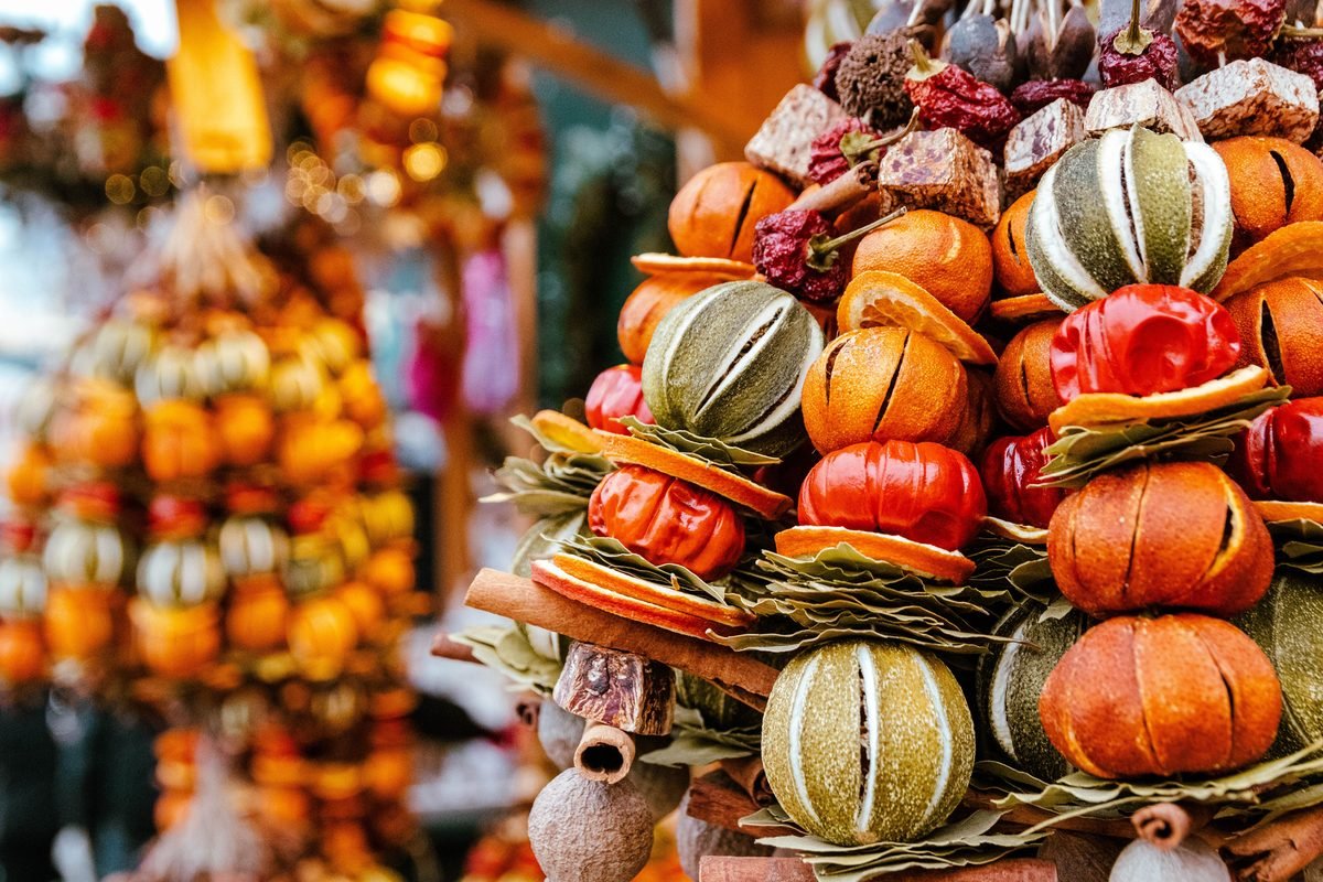 Display of colorful dried fruit and citrus arrangements at a local market.