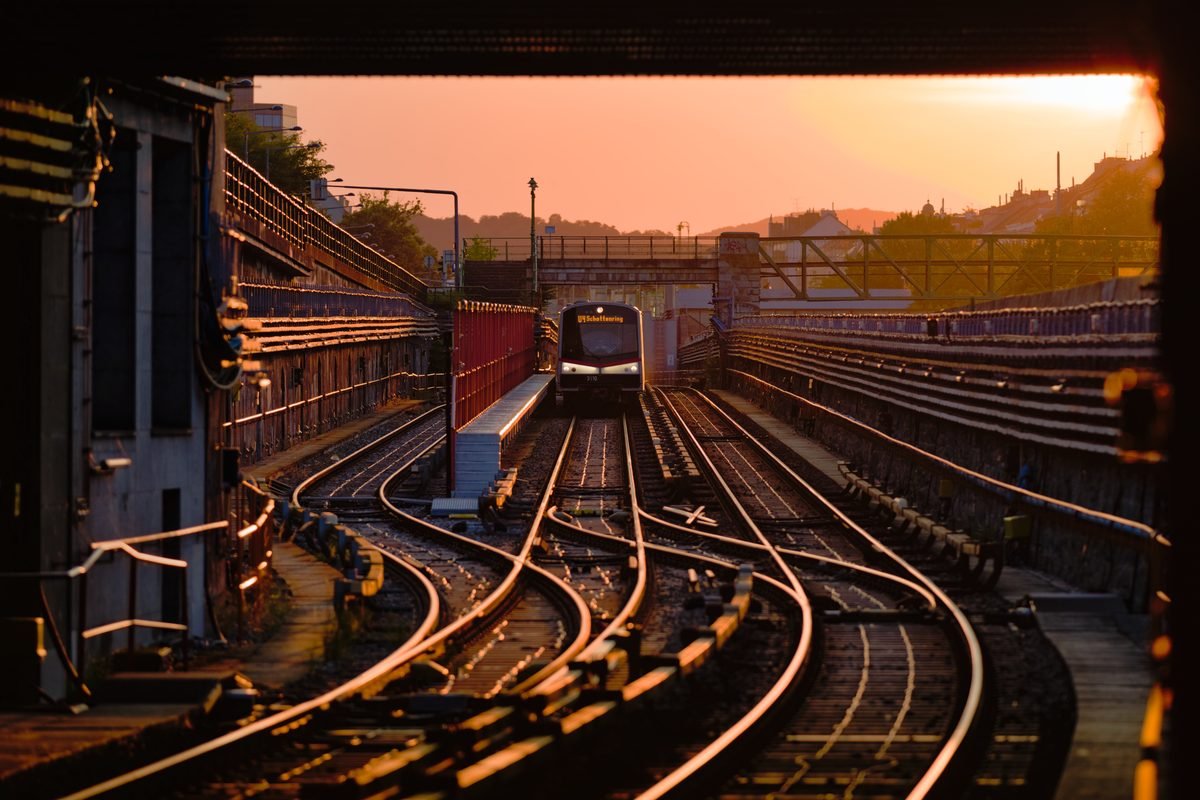 A Vienna U-Bahn train approaching Hietzing station during golden hour.