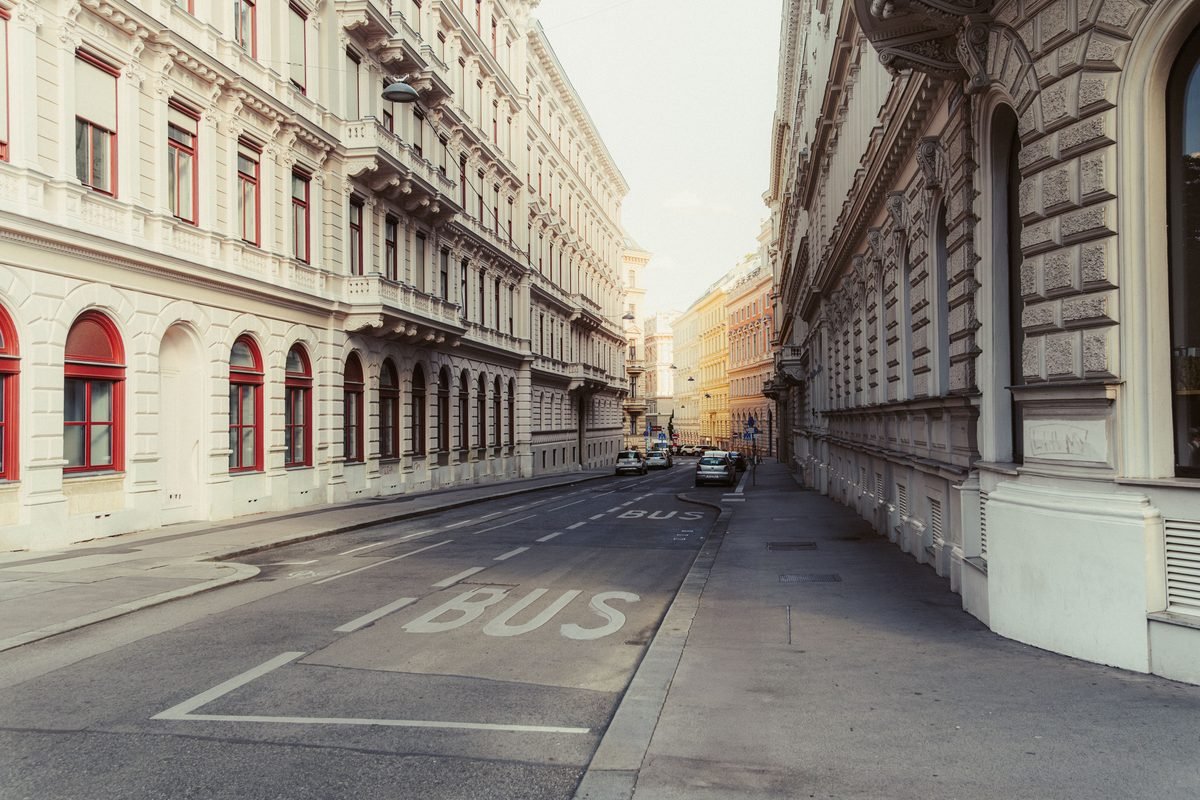 A quiet European street lined with classical white buildings.