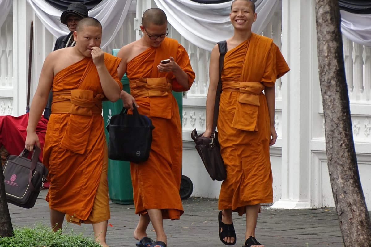Buddhist monks walking in a street in Bangkok.