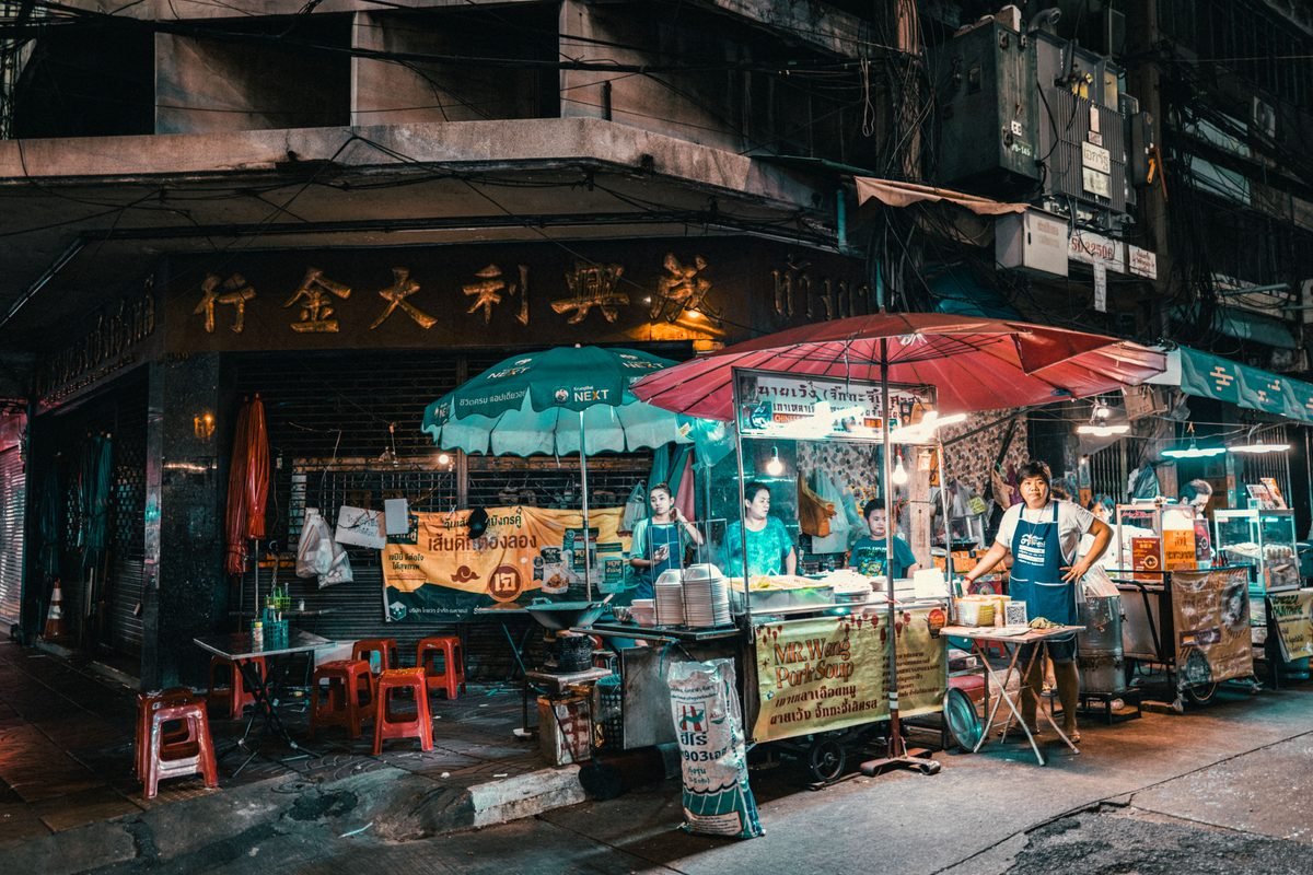 Vibrant night market scene in Bangkok showcasing street food vendors.