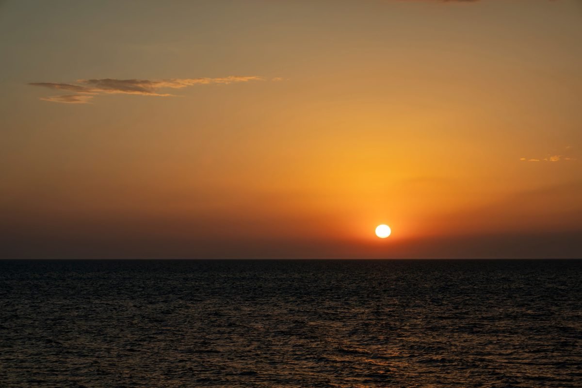 Sunset over the ocean with vibrant orange sky
