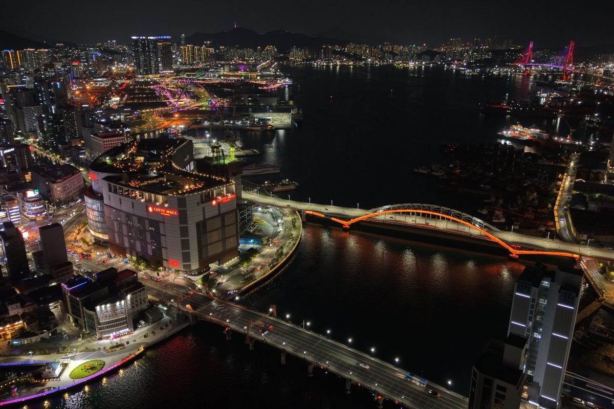Aerial view of Busan at night with illuminated bridges and buildings