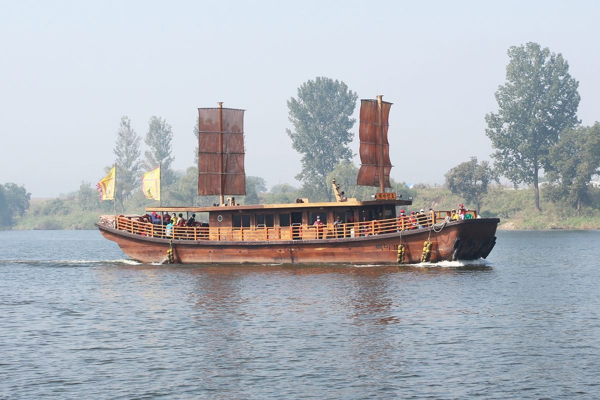 Traditional wooden ferry boat cruising on the Baengmagang River in Buyeo