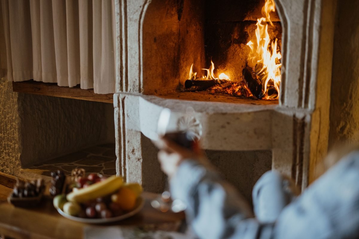 Warm stone fireplace with fruit and wine in a rustic cave room