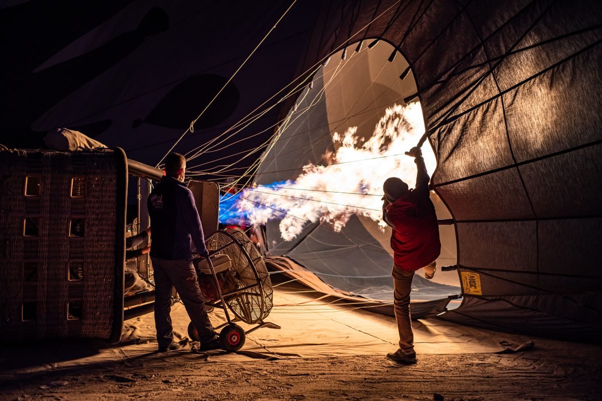 Hot air balloon burner flame illuminating the inside of the fabric at night