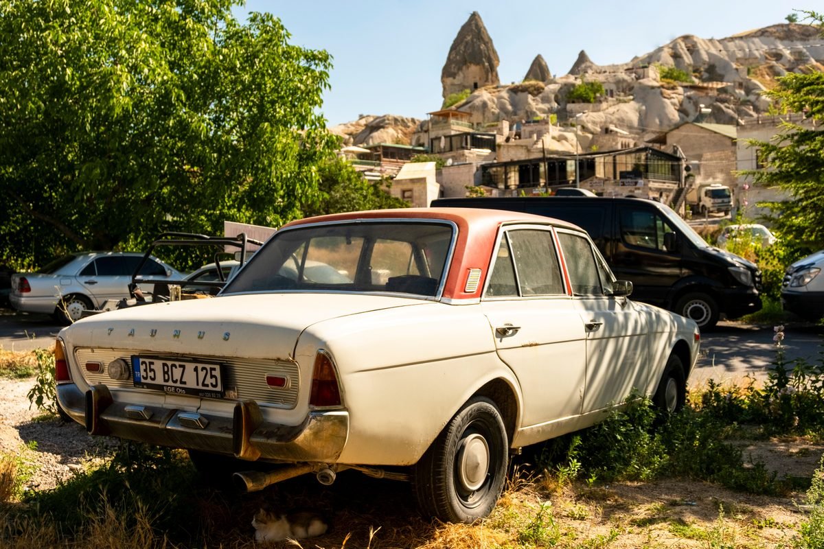 A vintage classic car parked in the scenic rocky landscape of Cappadocia