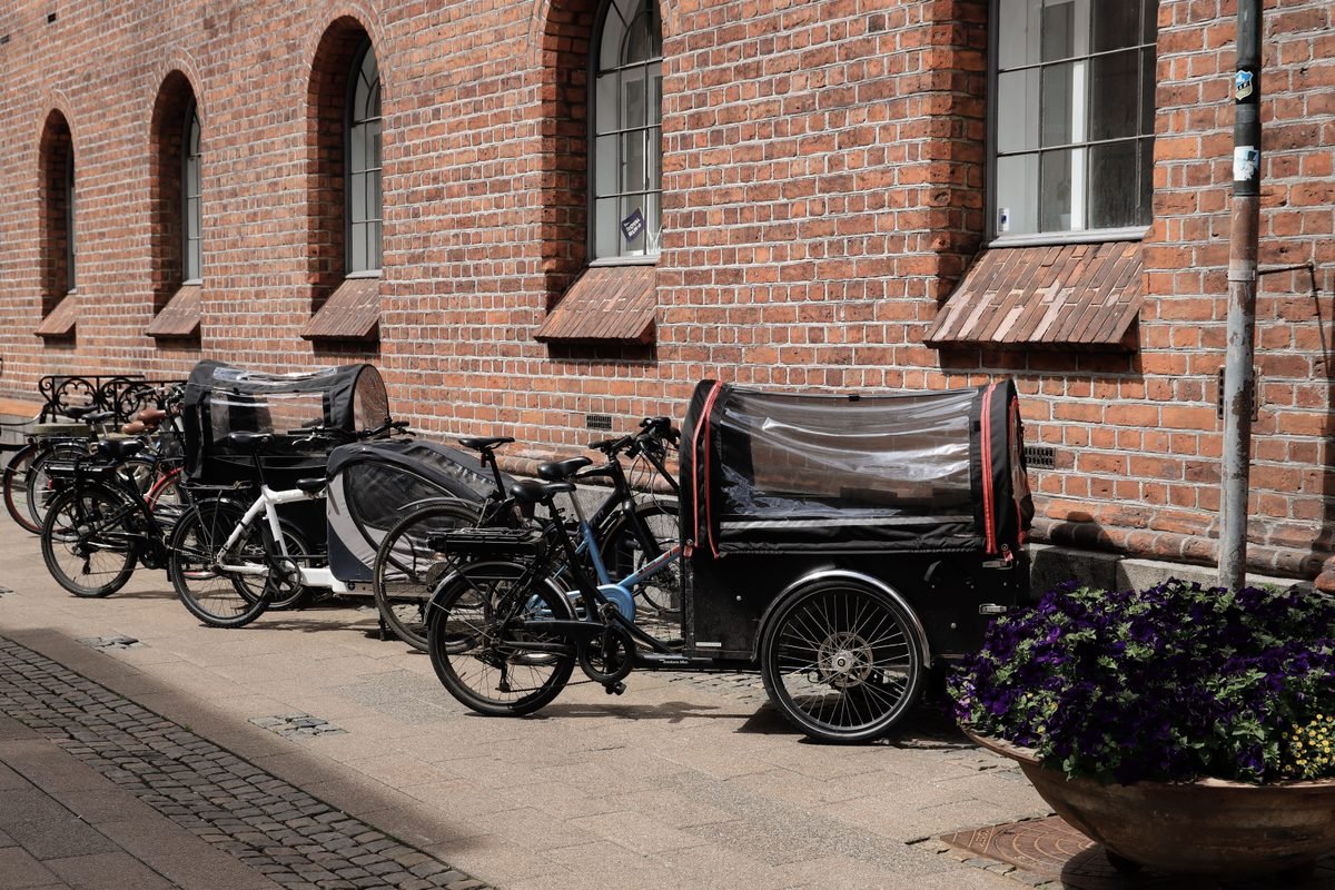Cargo bikes parked neatly along a historic red brick wall in Copenhagen