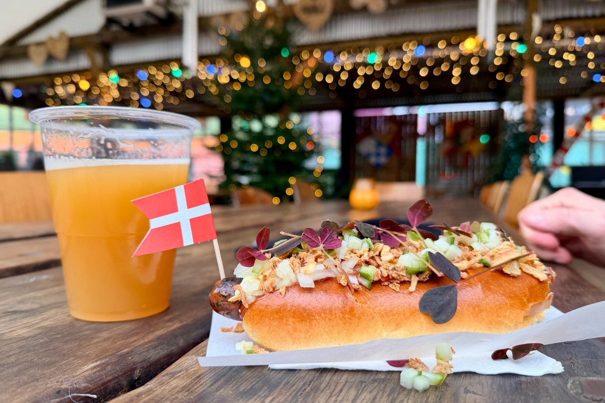 Traditional hot dog and beer garnished with fresh toppings on wooden table