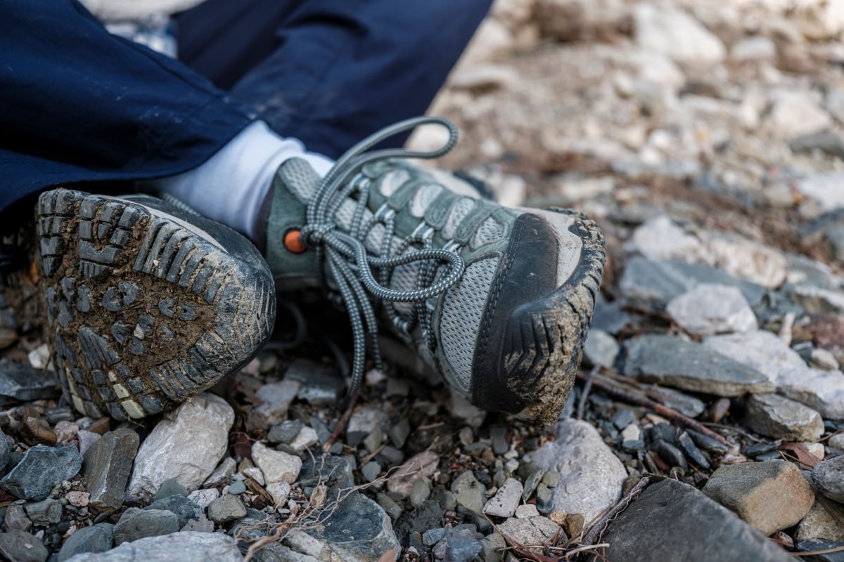 Muddy hiking boots on a rocky trail