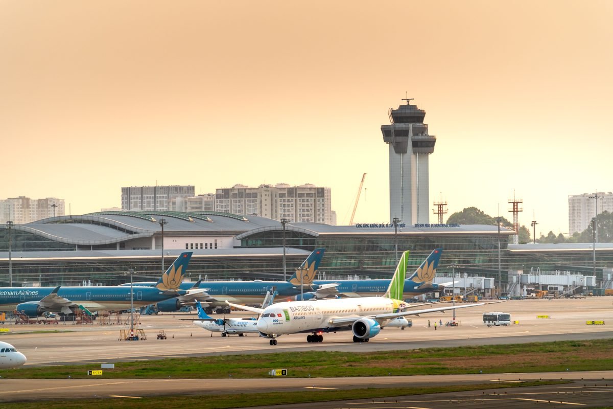 Airplanes parked on a runway at a modern airport terminal.