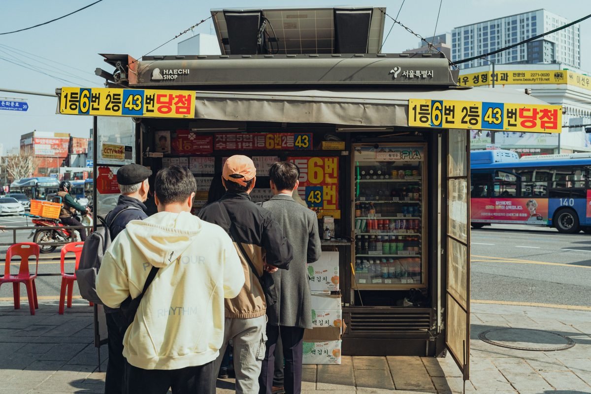 People waiting in line at a street kiosk in Seoul.