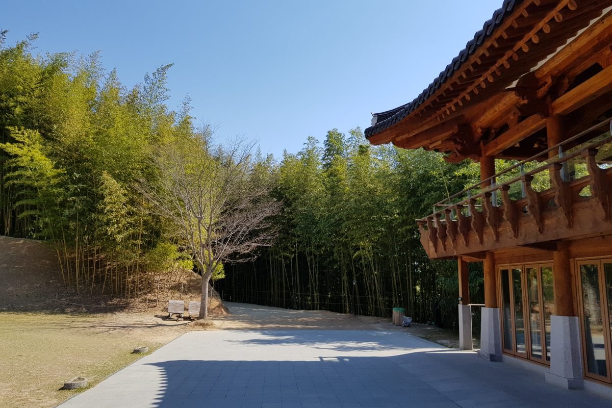 Traditional Korean building next to a pathway and bamboo forest in Damyang.
