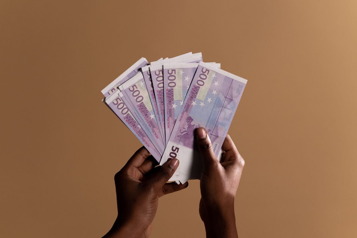 Hands holding a fan of five hundred euro banknotes