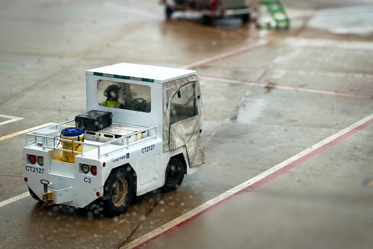 Small airport utility vehicle on a rainy tarmac