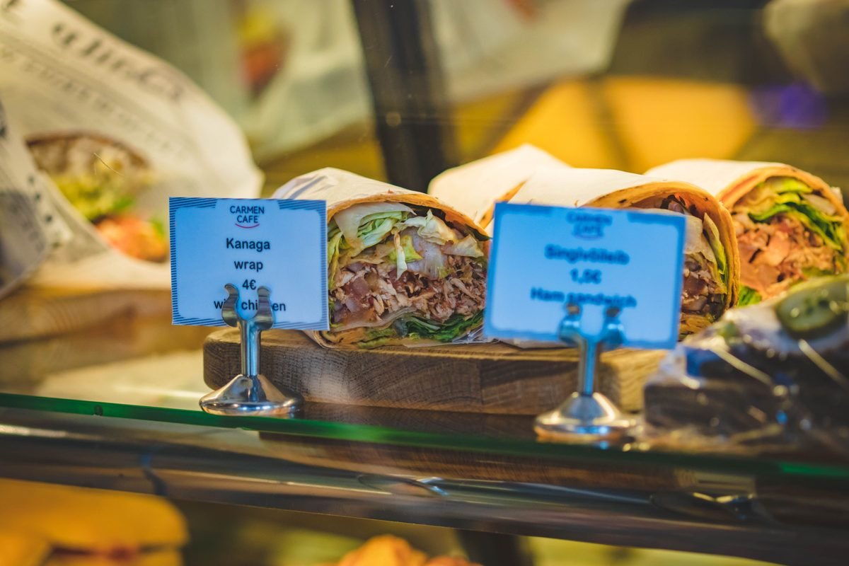 Chicken and ham wraps displayed at a cafe counter with price tags