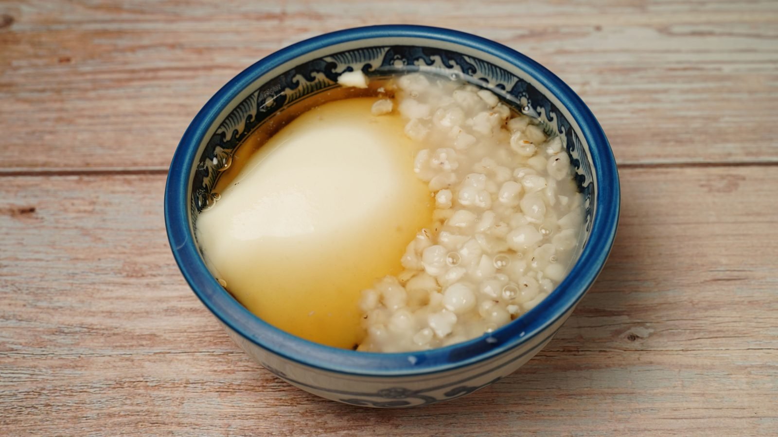 A bowl of traditional sweet soup with soft tofu and grains