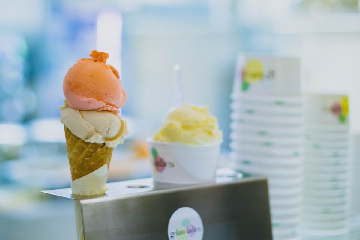 Assorted gelato scoops displayed in cups and cones