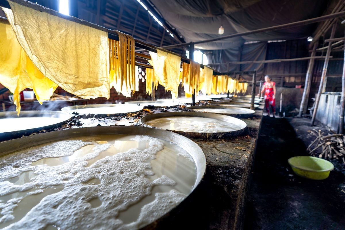 Traditional tofu production workshop with large metal vats of boiling soy milk