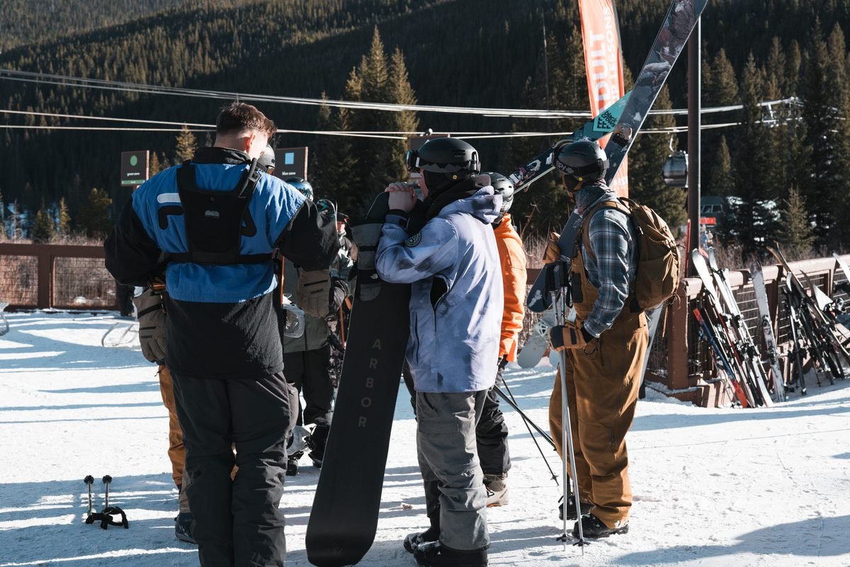 Winter sports enthusiasts gathering near ski racks at a resort