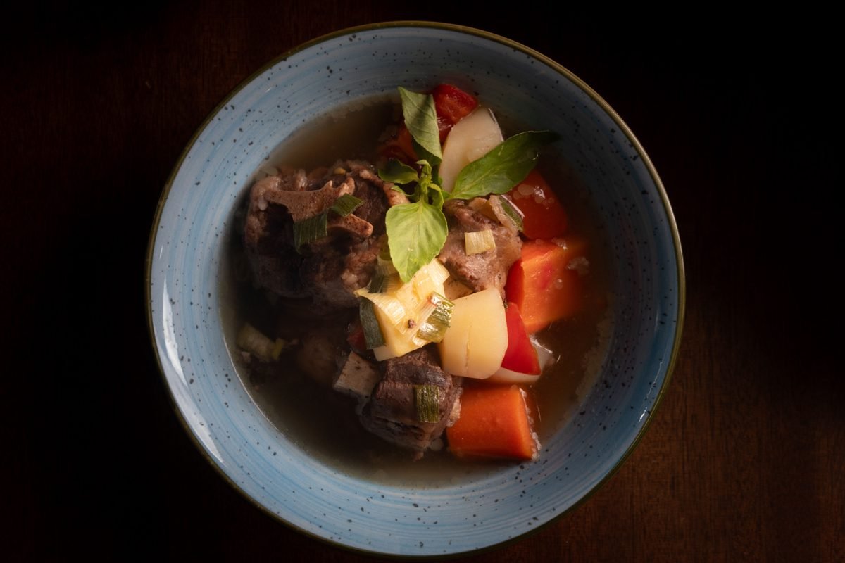 Hearty beef stew with vegetables served in a blue bowl