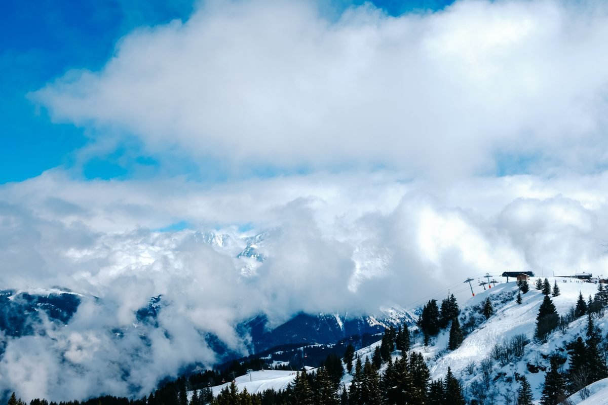 Snowy mountain peaks emerging through a layer of clouds