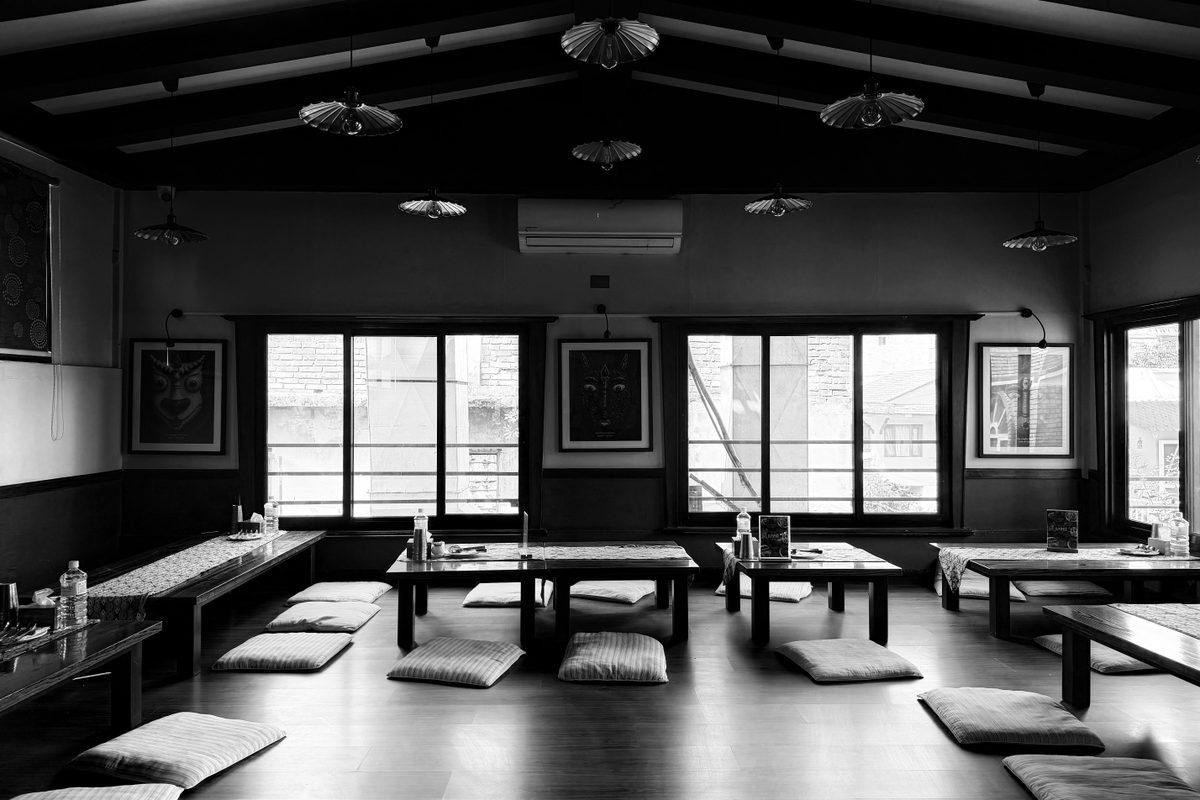 Minimalist restaurant interior with low tables and floor cushions.